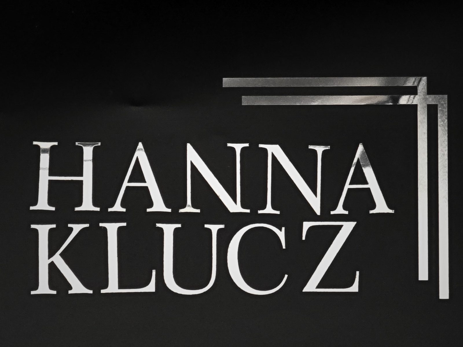 Zdjęcie przedstawia litery nagrobne ułożone wpoglądowe imię i nazwisko "Hanna Klucz". W prawym górnym rogu jest ozdoba.