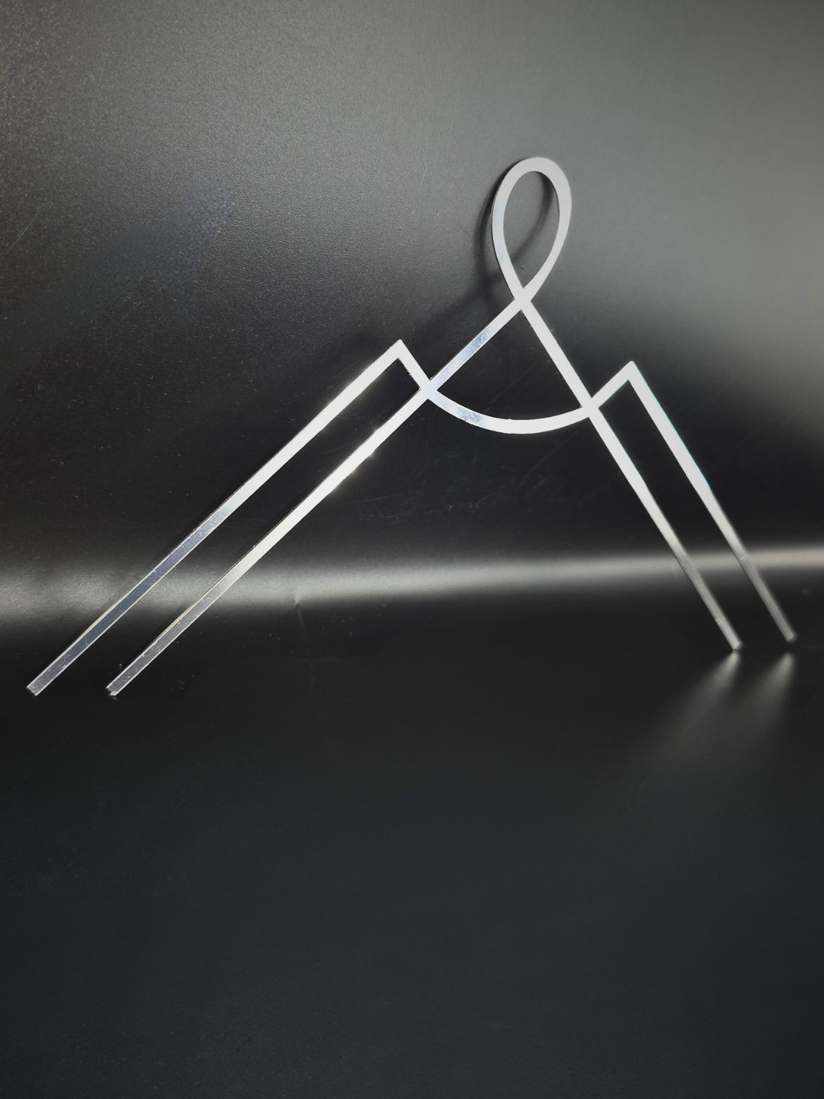 zdjęcie przedstawia metalowy dekor na pomnik. Jest to dekoracyjny ornament nagrobny do przyczepienia w rogu pomnika.