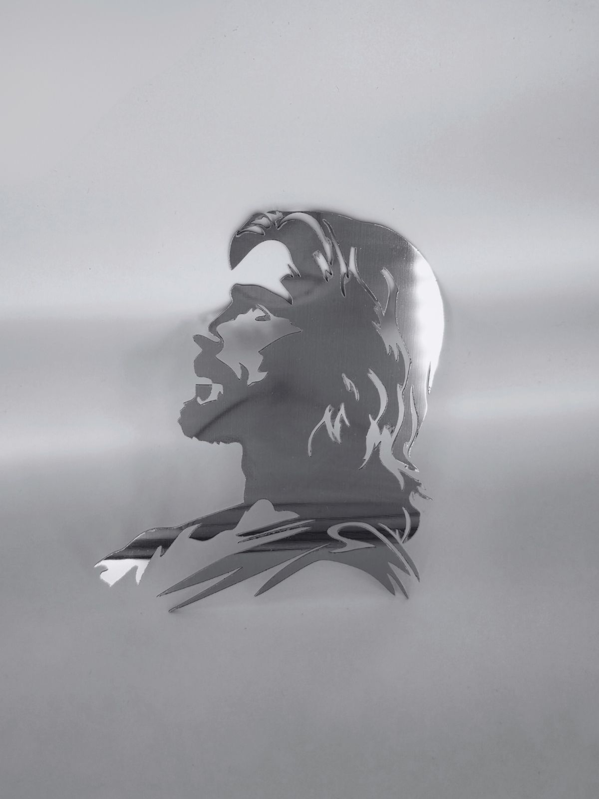 Zdjęcie przedstawia wykonany ze stali nierdzewnej profil Jezusa, Stoi na białym tle